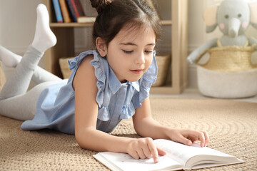 Sticker - Little girl reading book on floor at home