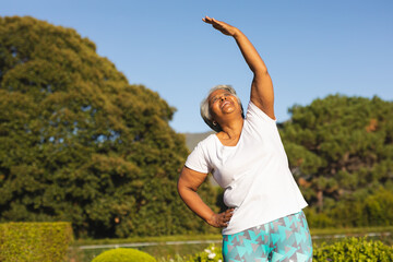 Senior smiling african american woman practicing yoga in stunning countryside