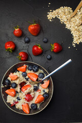 Wall Mural - The concept of a healthy breakfast of oatmeal with strawberries and blueberries