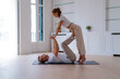 © ADDICTIVE STOCK - Couple practicing acro yoga together on floor at home
