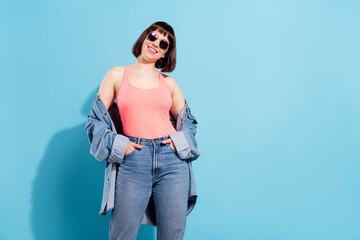 Poster - Photo of charming pretty young woman wear denim shirt dark eyewear arms pockets smiling isolated blue color background