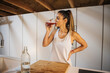 © ADDICTIVE STOCK - Sportswoman drinking fresh juice in kitchen at home