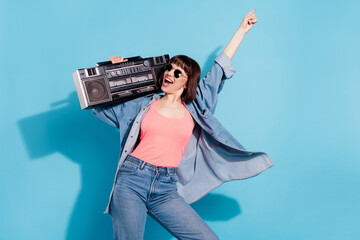 Wall Mural - Photo of astonished young lady dance with boom box wear pink top jeans eyewear isolated on blue color background