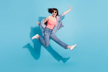 Wall Mural - Full body profile photo of astonished young lady jump wear top jeans eyewear isolated on blue color background