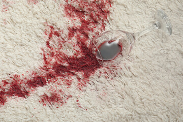 Poster - Overturned glass and spilled red wine on white carpet, top view