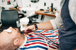 © ADDICTIVE STOCK - Crop barber cutting beard of client with trimmer in barbershop