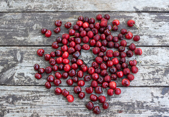 Red fresh cherries on wood table with star, close up. Ripe berries are delicious and contain healthy vitamins. Tasty cake to￼ is obtained from fresh fruits. Texture and background