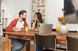 © LIGHTFIELD STUDIOS - Cheerful couple looking at each other near pancakes and laptops