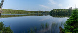 Fototapeta Na ścianę - panorama landscape of lush green summer forests with a calm and picturesque lake in the wilderness