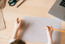 Child Trace Around A Hand On Paper With Pencil Using Video Lesson For Drawing. Distance Education