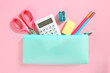 School supplies set top view on pink empty space background. Pencil case with accessories. Back to school