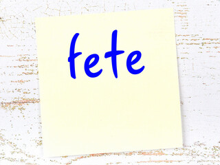 Yellow sheet of paper with word fete. Reminder concept