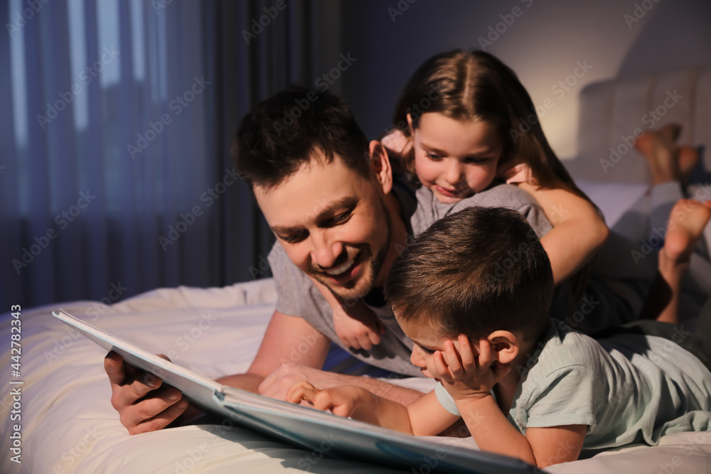 Father reading bedtime story to his children at home - obrazy, fototapety, plakaty 