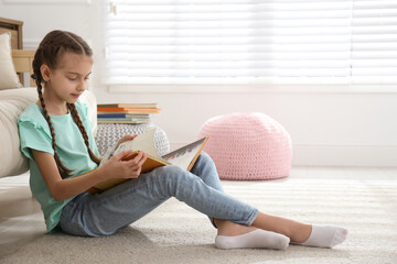 Sticker - Cute little girl reading book on floor at home