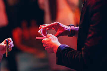 magician shows guests card tricks at the party close up hands.