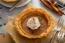 Small Pumpkin Pie With Whipped Cream And Cinnamon