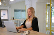 Smiling woman using laptop in work place for small businesses looking to engage audiences and scale content creation can adopt new marketing technology in workspace. Freelancer concept.