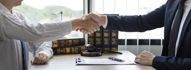 Wall Mural - Businessman shaking hands with a lawyer or judge After signing the contract and the agreement is complete, Approval of an agreement between business and law, End of the legal case.