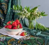 Fototapeta Mapy - Still life with ripe strawberries and a bouquet of spring flowers.