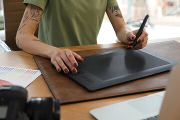 Poster - Professional designer with graphic tablet at wooden table, closeup