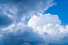 Natural Daylight And White And Dark Blue Clouds Floating On Blue Sky. White Fluffy Clouds And Blue Sky