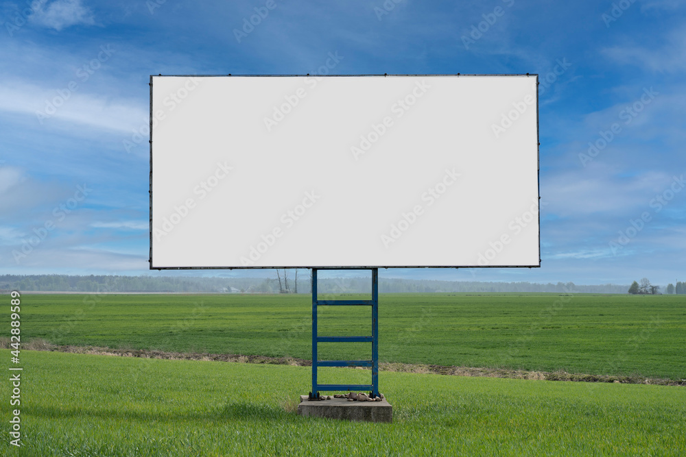 Duży pusty billboard ustawiony przy drodze w polu - obrazy, fototapety, plakaty 