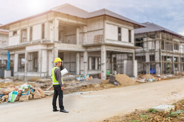 Wall Mural - young professional engineer in protective helmet and blueprints paper at the house building construction site