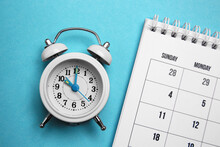 Alarm Clock And Calendar On Light Blue Background, Flat Lay. Reminder Concept