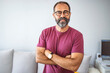 Smiling mature man wearing spectacles looking at camera. Portrait of confident man at home. Successful entrepreneur feeling satisfied. Portrait of confident mature businessman.