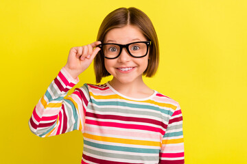 Wall Mural - Photo of charming adorable young small girl wear glasses smile good mood isolated on yellow color background