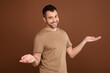 © deagreez - Photo of funny charming young gentleman wear beige t-shirt showing arms scales empty space smiling isolated brown color background