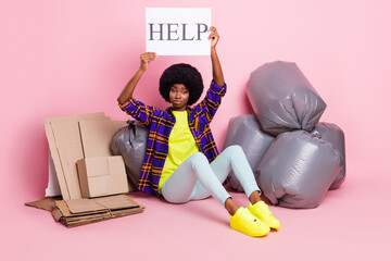 Sticker - Full length body size view of pretty miserable girl sitting with stack waste holding help card isolated over pink pastel color background