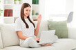 © deagreez - Photo of charming lady have video call communication laptop wave hand wear white t-shirt sit couch in room indoors