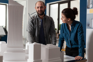 Poster - Construction architect team working at desk office on blueprint layout. Caucasian colleagues standing at maquette building model design plan to engineer construction project