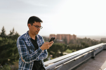 Focused man using smartphone on rooftop