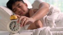 Happy young Asian man waking up in the morning.