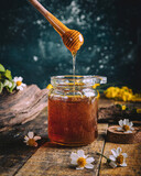 honey in a glass jar and flowers