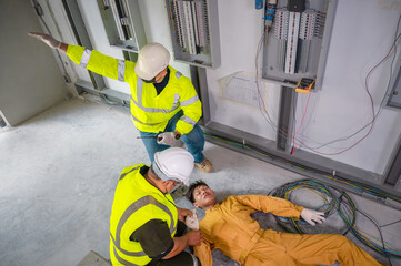 Wall Mural - Electric worker suffered an electric shock accident unconscious. Safety team CPR for first aid Electric worker loses in electric shock accident at work on site. Accident in control room of factory.