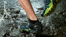 Close-up Of Man Feet Running In Water, Freeze Motion.