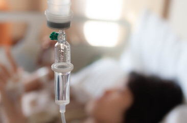 Set vitamin iv fluid intravenous drop saline drip with blur woman lying on bed in hospital room background. Medical Concept treatment emergency and injection drug infusion care chemotherapy concept.