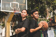 Two young Filipino friends after a street basketball game at a local court.