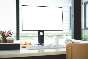 Creative workspace with computer, houseplant and office supplies on white table.