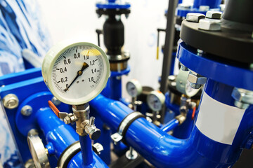 Pressure gauge on a piping system in an industrial boiler room. The mechanical pressure gauge displays zero on the instrument panel to indicate that the water supply has been cut off to the public