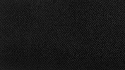 black herringbone pattern fabric, texture background. black and grey tweed pattern, weaving, textile material. close up canvas background. 