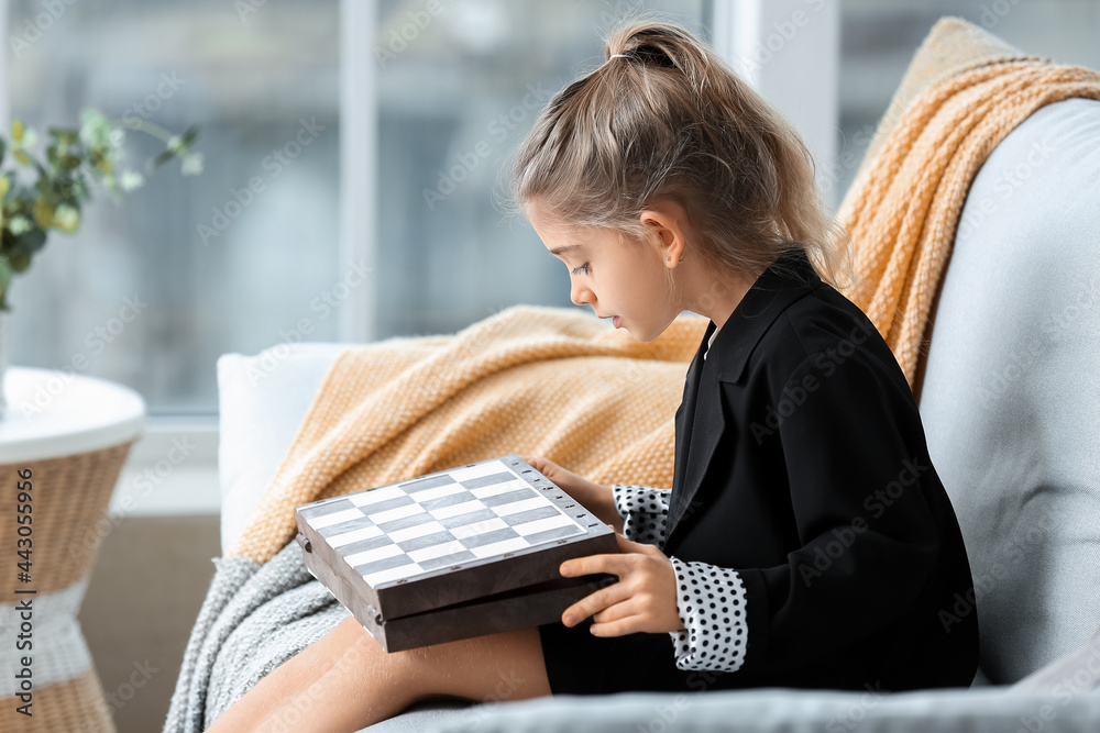 Cute little girl with chess at home