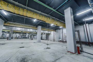 Construction of spacious well-lit underground car park with parking spaces. Empty parking garage underground, industrial interior