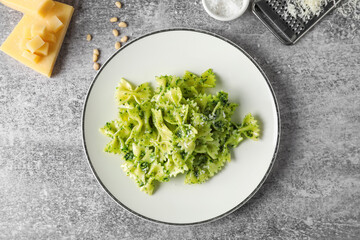 Plate with tasty pesto pasta on grunge background