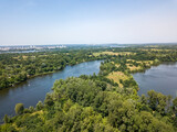 Fototapeta Miasto - River among green trees in summer. Aerial drone view.