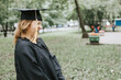 a middle-aged woman in the clothes of a graduate a coat and a cap celebrates the completion of college and obtaining a new specialty