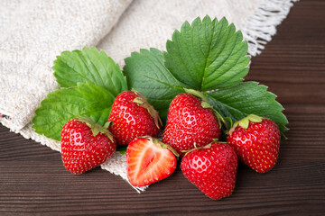 Wall Mural - Top view of beautiful composition of delicious ripe strawberries on a dark table and a white towel. Strawberry background